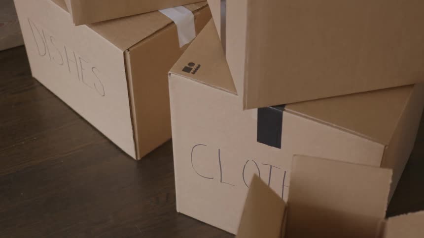 Cardboard boxes labeled with moving items on the floor