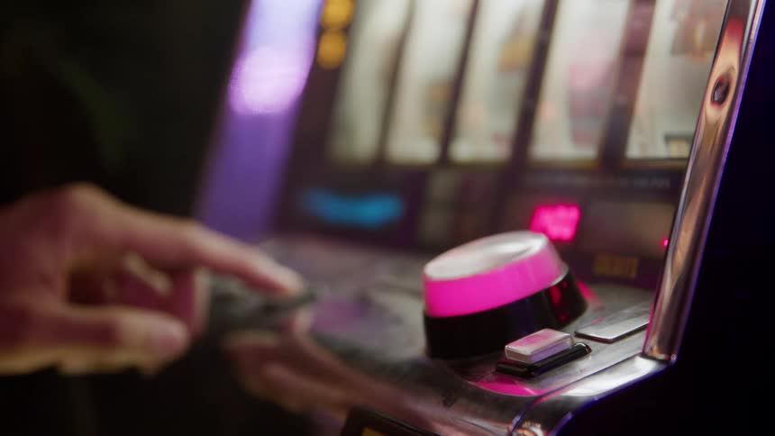 A hand pushes a large button on a console