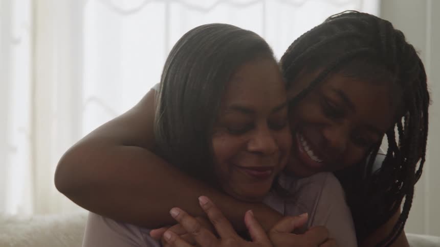 Warm smiles in a loving embrace between mother and daughter