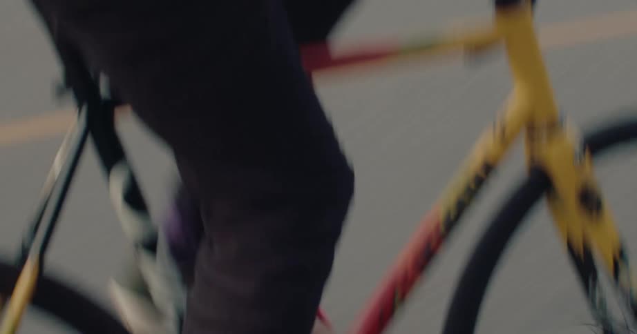 A man is pedaling his bike really fast on a road in the mountains
