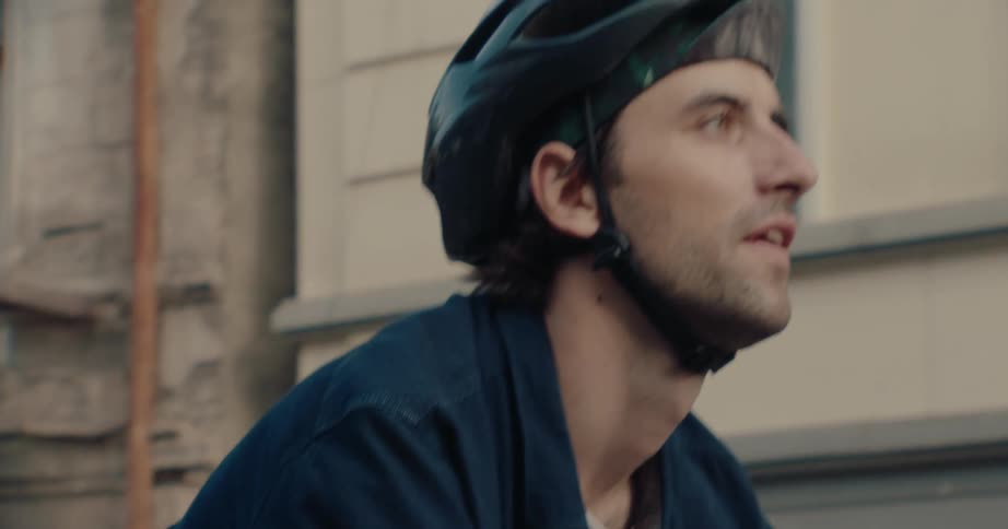 Man rides through the city wearing a cycling helmet
