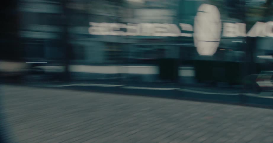 Cyclist rides through an urban area reflected on glass facades