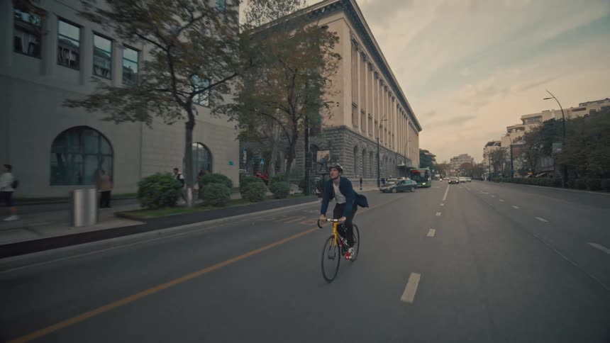 A man riding a bicycle on a large city road