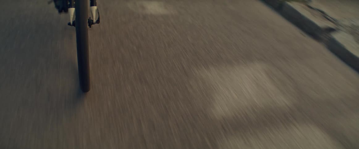 Front wheel of a bicycle moving along the asphalt