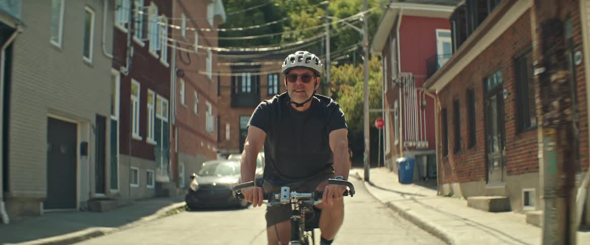 A man rides his bike down a street