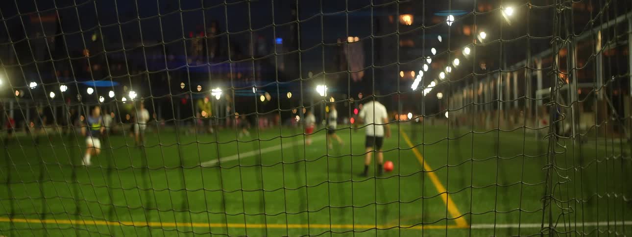 Soccer player kicks the ball as other players move on the field