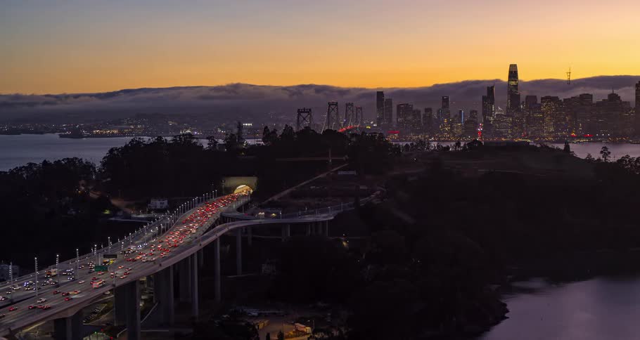 A large amount of vehicle traffic passes over a bridge near a major city