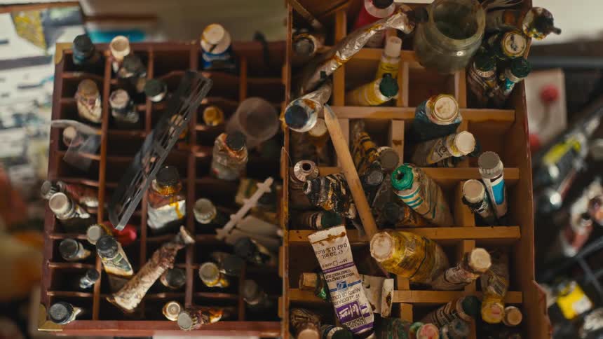 Tubes of paint and brushes organized in wooden boxes seen from above
