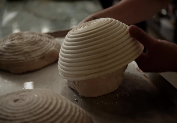 Bread dough being covered with a proofing basket
