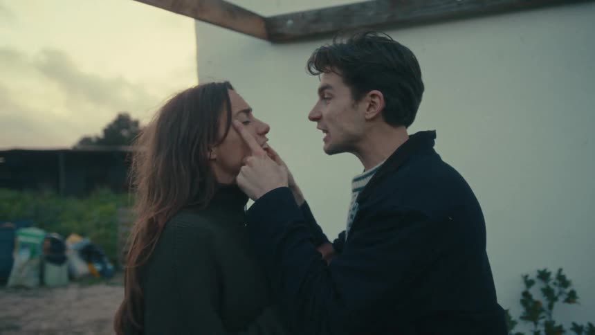 A man is being aggressive and pushing into a woman as he yells at her and she pushes him away