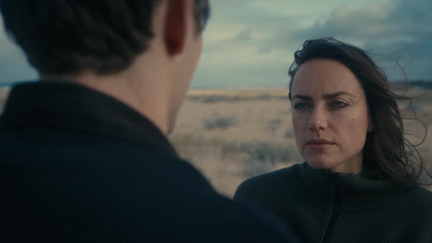 Woman staring at man with a serious expression in a coastal landscape