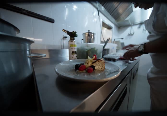 The chef is plating a meal in the restaurant