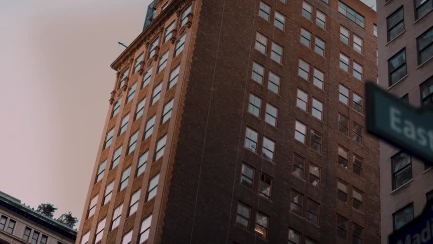 Tall brick building seen from below under soft late afternoon light