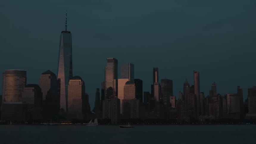 Skyscrapers reflect the last rays of sunlight over the river at dusk