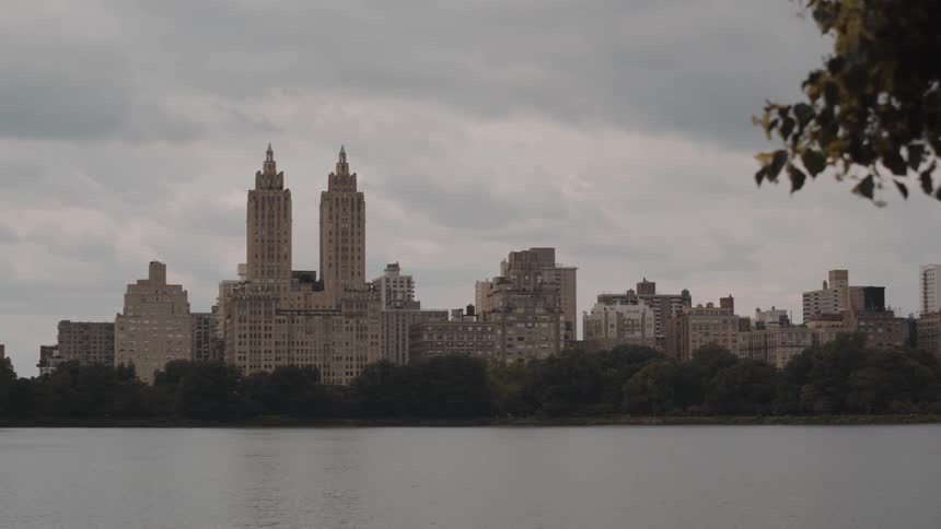 Thick clouds hang over a city that has a river going through it