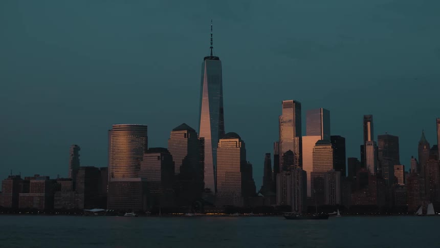 Sunlight shines on towers and skyscrapers on the metropolitan coast as boats sail on the water