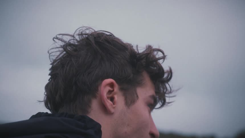 Windtousled hair as he gazes toward the horizon