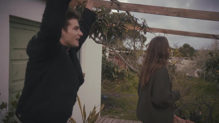 Man smiles energetically while the woman watches him in silence