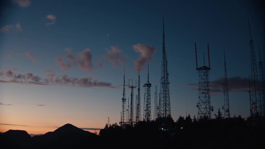 Transmission towers stand out against the blue sky at sunset