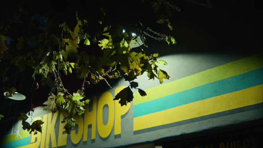 Colorful bike shop facade lit up at night