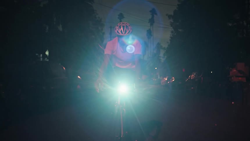 A man riding a bicycle down a road at night