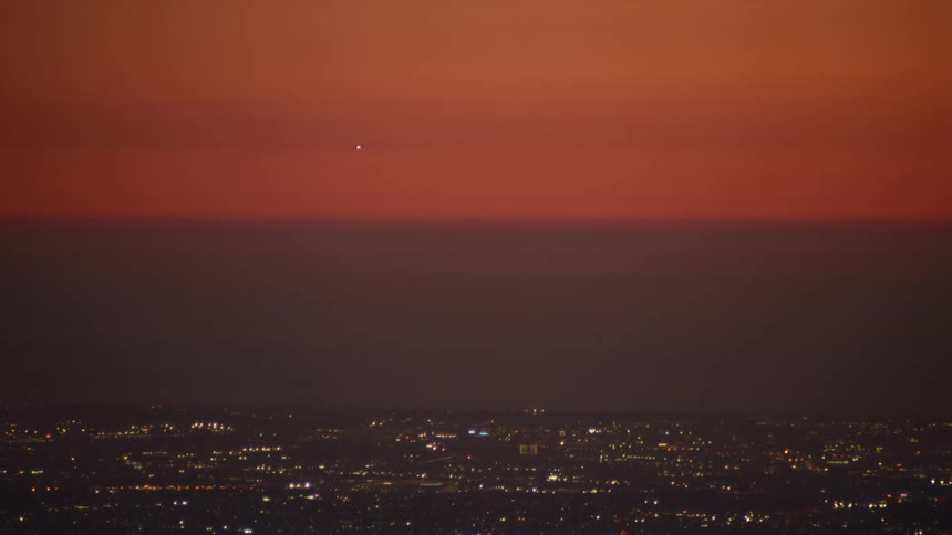 City skyline glows beneath a deep orange sunset