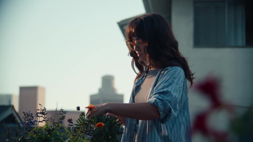 A woman arranging flowers in a flower bed
