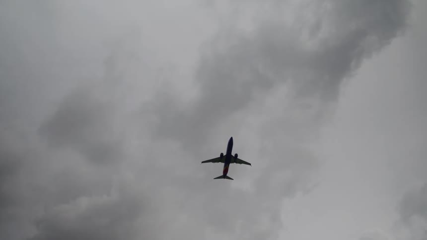 Jet airplane flying across a cloudy sky