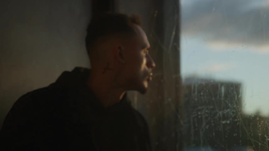 Man looks out the window while standing inside an elevator