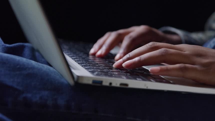 The person is typing on their laptop