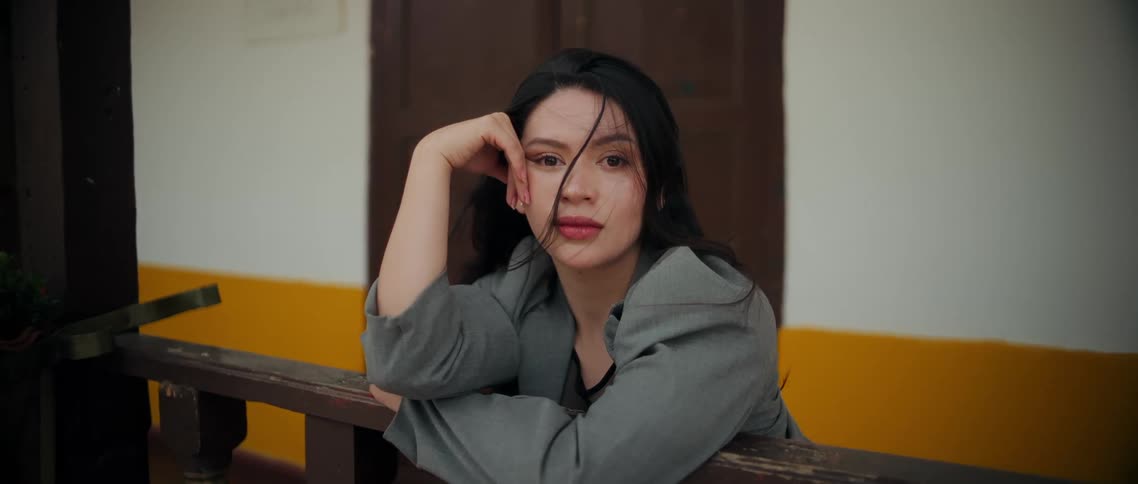Woman rests her arm on the railing while looking directly