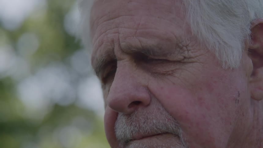 Close up view of the face of an elderly man outside