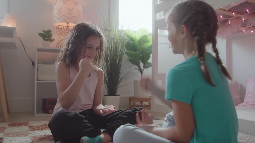 Kids sitting in the bedroom playing rock paper scissors