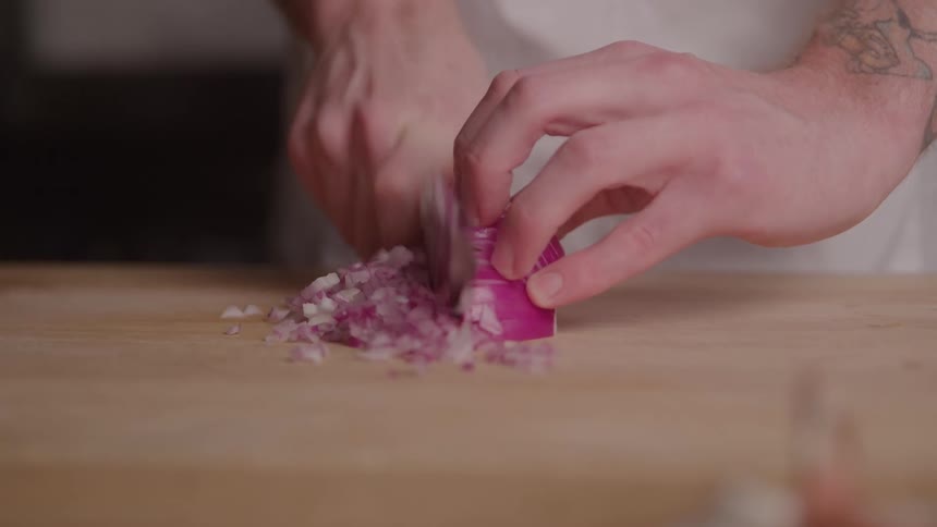 Cook finely chopping red onion on the cutting board