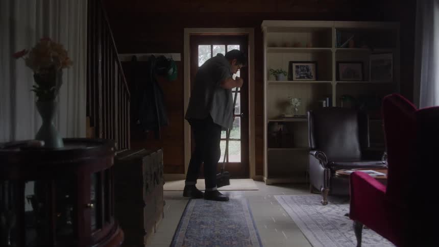 Man sweeping the floor near the homes front door