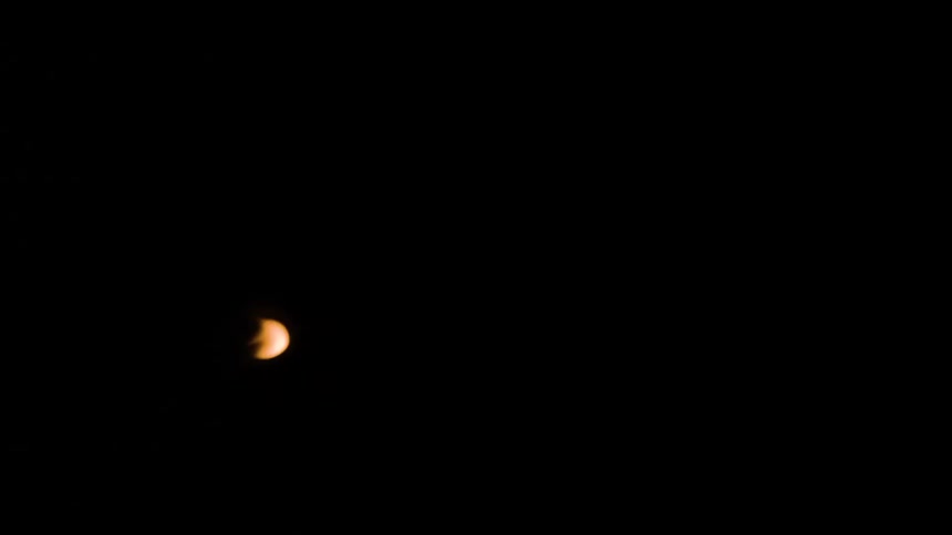 A flame turns into a plume of soft goldenorange smoke across a completely black background