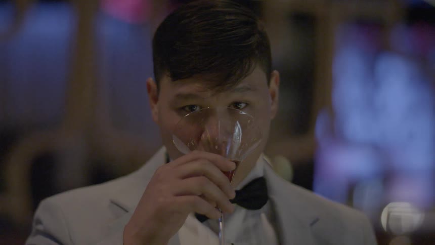 Man in suit drinking a cocktail