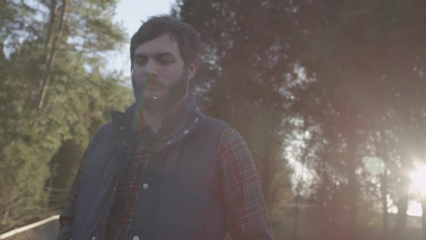 Man standing still outside in wooded area