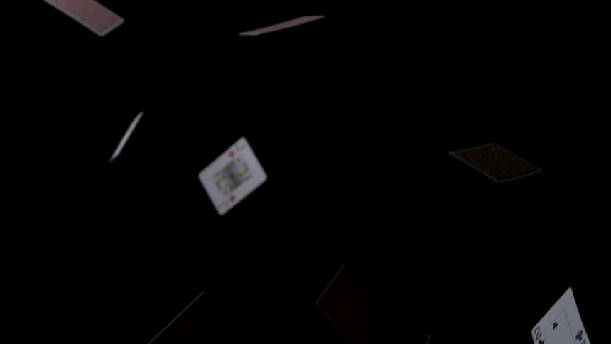 Several playing cards are falling onto a completely black background