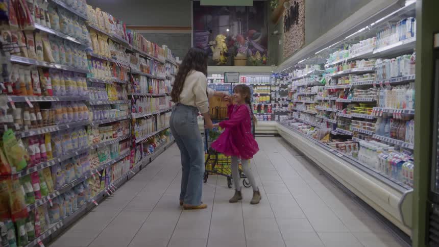 A woman and daughter dance in a supermarket