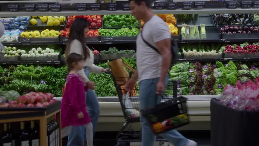 Two people walking past each other in a grocery store