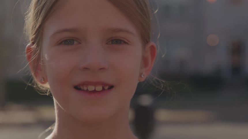 A portrait of a girl standing outdoors