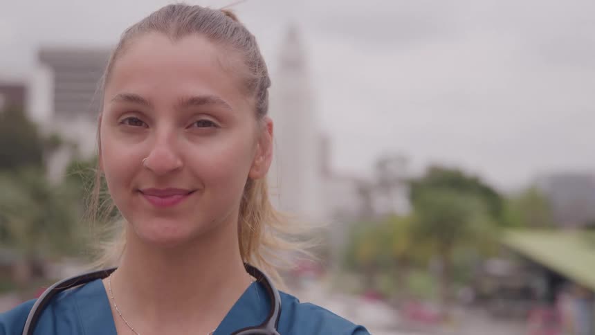 Smiling healthcare professional with a stethoscope outdoors