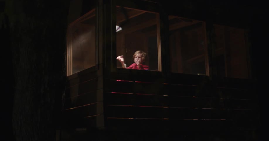 Child waves arms around in a small room at night