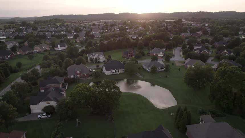 The sun hovers over the horizon of a large neighborhood