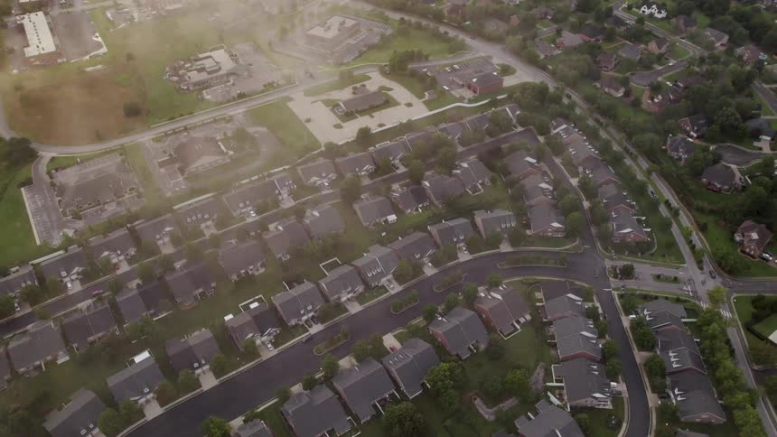 Aerial view showing an organized residential neighborhood with aligned houses and curved streets