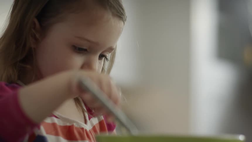 Child stirs batter with a spatula