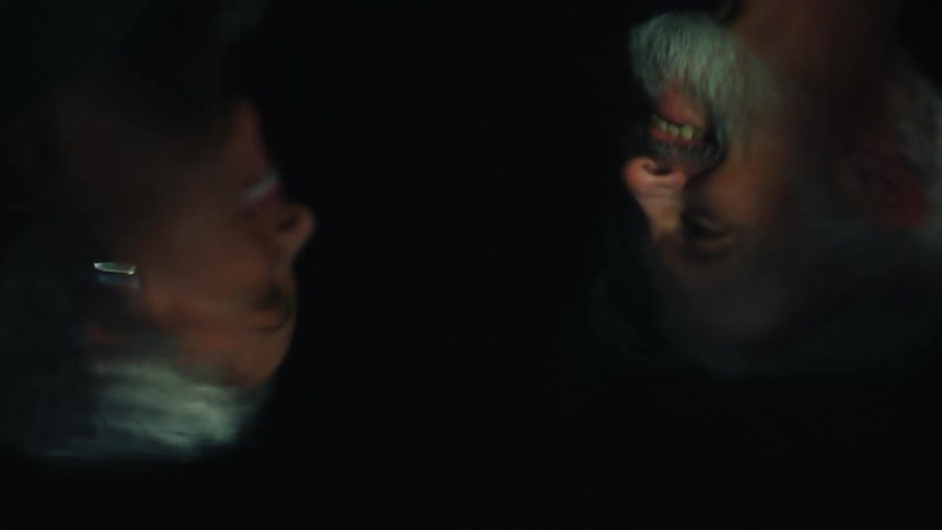 Reflection of a smiling couple appears upside down against a dark background