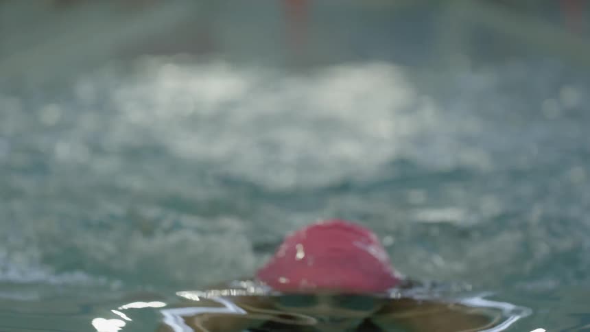 A close up view of some water splashing around and a woman jumping in and out of it