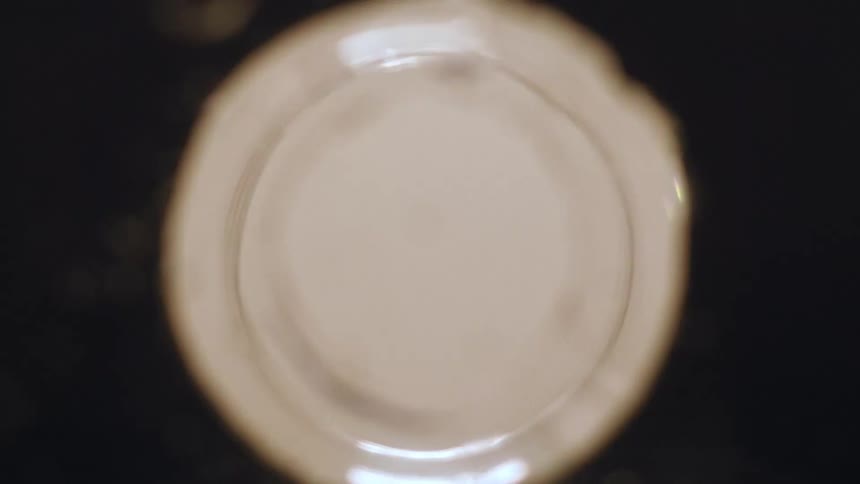 Extreme closeup of a man spitting into a sink while brushing his teeth